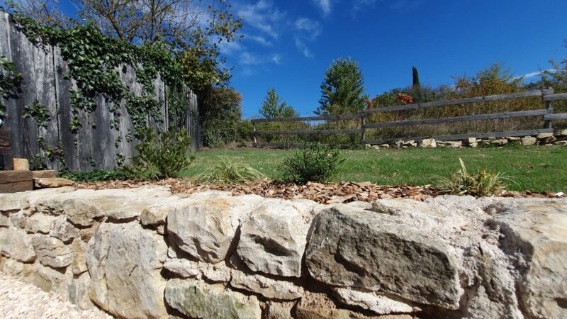 Mur en pierres au bord de la terrasse et ciel bleu